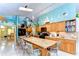 Bright kitchen with island seating, oak cabinets, stainless appliances, and beach mural at 14119 Stonegate Dr, Tampa, FL 33624