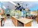 Open kitchen boasts island, stone countertops, breakfast bar, modern appliances, and travertine floor at 14119 Stonegate Dr, Tampa, FL 33624