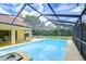Enclosed pool area featuring a pristine blue pool, an open patio, and lush greenery at 14119 Stonegate Dr, Tampa, FL 33624