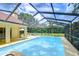 Screened-in pool area with shimmering pool, lush landscaping, lounge chairs, and plenty of natural light at 14119 Stonegate Dr, Tampa, FL 33624