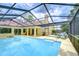 Screened-in pool with lounge chairs, spacious patio, and sliding glass doors to the interior of the home at 14119 Stonegate Dr, Tampa, FL 33624