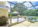 Screened-in patio with tiled area and outdoor furniture, perfect for entertaining by the pool at 14119 Stonegate Dr, Tampa, FL 33624