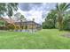 View of the screened-in pool with an expansive lawn and lush landscaping, offering a private backyard oasis at 14119 Stonegate Dr, Tampa, FL 33624