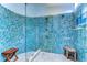 Eye-catching walk-in shower adorned with blue tiles, multiple shower heads and glass door at 14119 Stonegate Dr, Tampa, FL 33624