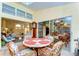 Bright sunroom with tile floors, a unique round table with chairs, and views into the living room and dining room at 14119 Stonegate Dr, Tampa, FL 33624