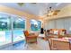 Cozy sunroom featuring wicker furniture, a ceiling fan, and views of the pool area at 14119 Stonegate Dr, Tampa, FL 33624