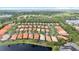 Aerial view of a community showcasing single Gathering homes, a serene lake, and mature trees in the background at 14521 Mirasol Manor Ct, Tampa, FL 33626