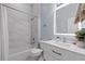 Bright bathroom featuring white tile and fixtures, updated vanity, and modern lighting at 14521 Mirasol Manor Ct, Tampa, FL 33626