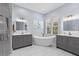 Bright bathroom featuring dual vanities, soaking tub, marble floors, and updated fixtures at 14521 Mirasol Manor Ct, Tampa, FL 33626