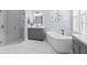 Bright bathroom featuring dual vanities, soaking tub, marble floors, and updated fixtures at 14521 Mirasol Manor Ct, Tampa, FL 33626