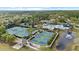 Aerial view of a community clubhouse, pool, and tennis and pickleball courts surrounded by lush landscaping at 14521 Mirasol Manor Ct, Tampa, FL 33626
