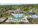 Aerial view of a luxurious community pool area with palm trees, a slide, and comfortable lounge seating at 14521 Mirasol Manor Ct, Tampa, FL 33626