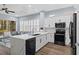 Open-concept kitchen with a large island, white cabinetry, stainless steel appliances, and views of the adjacent living area at 14521 Mirasol Manor Ct, Tampa, FL 33626