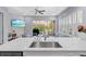 Bright, open floor plan with an island, living area, and sliding glass doors leading to outdoor living space at 14521 Mirasol Manor Ct, Tampa, FL 33626