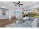 Stylish living room with a sleek sectional sofa, modern decor, and seamless access to outdoor patio and backyard at 14521 Mirasol Manor Ct, Tampa, FL 33626
