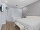 Modern main bedroom with light gray accent wall, hardwood floors, and bright sunny windows at 14521 Mirasol Manor Ct, Tampa, FL 33626