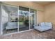 Covered brick patio with comfortable seating and a glimpse into the bright, modern kitchen at 14521 Mirasol Manor Ct, Tampa, FL 33626