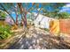 View of the backyard with mature trees, a wood fence, and lush landscaping at 150 23Rd N Ave, St Petersburg, FL 33704