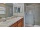 Bathroom featuring double sinks with cabinets and a glass door walk-in shower at 15411 Quail Woods Pl, Ruskin, FL 33573