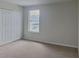 Carpeted bedroom with large closet and window allowing natural light at 15411 Quail Woods Pl, Ruskin, FL 33573