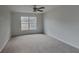 Large carpeted bedroom with a ceiling fan and window at 15411 Quail Woods Pl, Ruskin, FL 33573