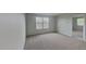 Bright bedroom with neutral walls and plush carpeting, featuring a large window for natural light at 15411 Quail Woods Pl, Ruskin, FL 33573