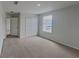 Carpeted bedroom featuring a closet, a window, and an open door at 15411 Quail Woods Pl, Ruskin, FL 33573