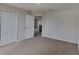 Carpeted bedroom with closet and open doorway showing view into the home at 15411 Quail Woods Pl, Ruskin, FL 33573