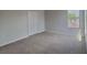 Bedroom features carpet flooring, a window, and a closet with double doors at 15411 Quail Woods Pl, Ruskin, FL 33573