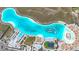 Aerial view of a resort-style community pool with playgrounds, lounge chairs, and cabanas by a beautiful, blue lagoon at 17228 Holly Well Ave, Wimauma, FL 33598