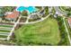 Aerial view shows the large lawn, pool, tennis courts, and bocce ball courts at 17228 Holly Well Ave, Wimauma, FL 33598