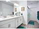 Bright bathroom featuring double sinks, white cabinets, a glass-enclosed shower, and modern fixtures at 17228 Holly Well Ave, Wimauma, FL 33598