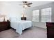 Bright bedroom with neutral carpet, ceiling fan and two large windows at 17228 Holly Well Ave, Wimauma, FL 33598