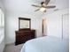Spacious bedroom featuring carpet, ceiling fan, dresser and a light blue quilt on the bed at 17228 Holly Well Ave, Wimauma, FL 33598