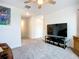 Open bonus room features neutral carpet, ceiling fan, and a television with media console at 17228 Holly Well Ave, Wimauma, FL 33598