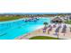 A look at the community lagoon bar area and lounge chairs with shady umbrellas for the sandy beach area at 17228 Holly Well Ave, Wimauma, FL 33598