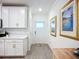 Bright entryway features light wood floors and white walls with decorative paintings at 17228 Holly Well Ave, Wimauma, FL 33598
