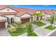 Charming single-Gathering home featuring a red tile roof, paver driveway, lush landscaping, and an attached two-car garage at 17228 Holly Well Ave, Wimauma, FL 33598
