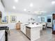 Modern kitchen featuring stainless steel appliances, a kitchen island, and a view into the dining and living spaces at 17228 Holly Well Ave, Wimauma, FL 33598