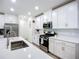 Kitchen featuring a stainless steel gas range, microwave and sink with bright white countertops and cabinets at 17228 Holly Well Ave, Wimauma, FL 33598