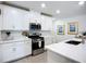 Bright kitchen with stainless steel appliances, white cabinets and quartz countertops at 17228 Holly Well Ave, Wimauma, FL 33598
