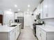 Bright kitchen with white cabinetry, stainless steel appliances and a gas range at 17228 Holly Well Ave, Wimauma, FL 33598