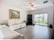 The living room features hardwood floors, a white sofa, and a sliding glass door to the backyard at 17228 Holly Well Ave, Wimauma, FL 33598