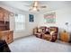 Living room with a ceiling fan, artwork, wooden furniture, and a brown leather recliner sofa at 17228 Holly Well Ave, Wimauma, FL 33598