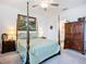 Primary bedroom featuring a four-poster bed, dresser, and decorative artwork at 17228 Holly Well Ave, Wimauma, FL 33598