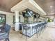 Outdoor bar with multiple TVs and lots of seating in an open-air community space at 17228 Holly Well Ave, Wimauma, FL 33598