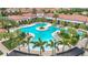 An aerial view of the community pool and recreation area, surrounded by palm trees and lounge chairs at 17228 Holly Well Ave, Wimauma, FL 33598