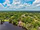 Picturesque aerial view of a home nestled among lush trees near a serene lake at 17301 Estes Rd, Lutz, FL 33548