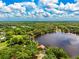 An impressive aerial view of a serene lake with a home, capturing its natural beauty and tranquil lakeside living at 17301 Estes Rd, Lutz, FL 33548