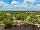 Gorgeous aerial view features a waterfront home, complete with boat dock, enveloped by mature trees and a picturesque lake at 17301 Estes Rd, Lutz, FL 33548